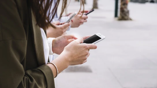 Tres personas conectadas con su móvil. Nomofobia