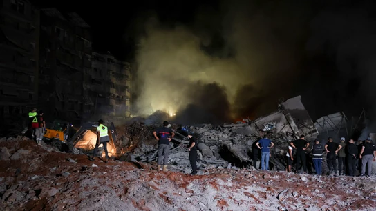 La gente inspecciona los daños en el lugar de un ataque israelí La gente inspecciona los daños en el lugar de un ataque israelí