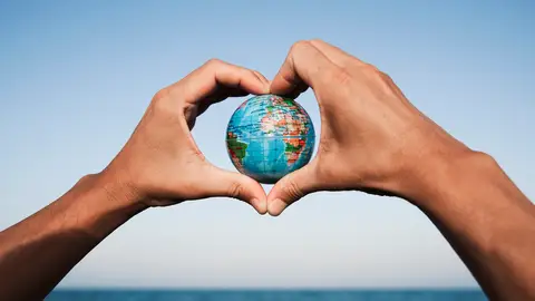 Hombre con una miniatura del planeta en sus manos Hombre con una miniatura del planeta en sus manos