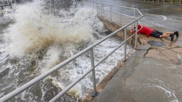 Un visitante desafía las fuertes olas, la marejada ciclónica y los fuertes vientos del huracán Helene para tomar fotografías en el centro de Cedar Key, Florida, EEUU, a 26 de septiembre de 2024. 