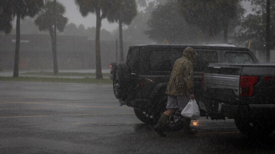 Un hombre camina bajo la lluvia ante la inminente llegada del huracán Helene. 
