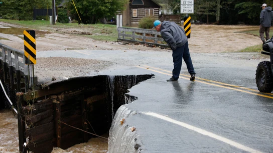 Un transeúnte inspecciona la parte derrumbada de un puente después de que las aguas de la inundación lo destruyeran durante la tormenta tropical Helene Un transeúnte inspecciona la parte derrumbada de un puente después de que las aguas de la inundación lo destruyeran durante la tormenta tropical Helene