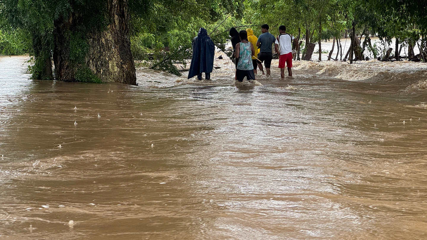Personas caminan por una calle inundada tras el paso del huracán 'John', este sábado en el municipio de Coicoyán de Las Flores (México). Personas caminan por una calle inundada tras el paso del huracán 'John', este sábado en el municipio de Coicoyán de Las Flores (México).