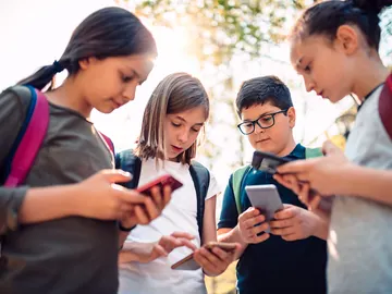 Niños adolescentes con el teléfono móvil Niños adolescentes con el teléfono móvil