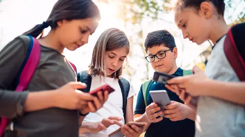 Niños adolescentes con el teléfono móvil Niños adolescentes con el teléfono móvil