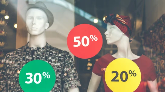 El escaparate de una tienda de ropa anuncia descuentos. El escaparate de una tienda de ropa anuncia descuentos.