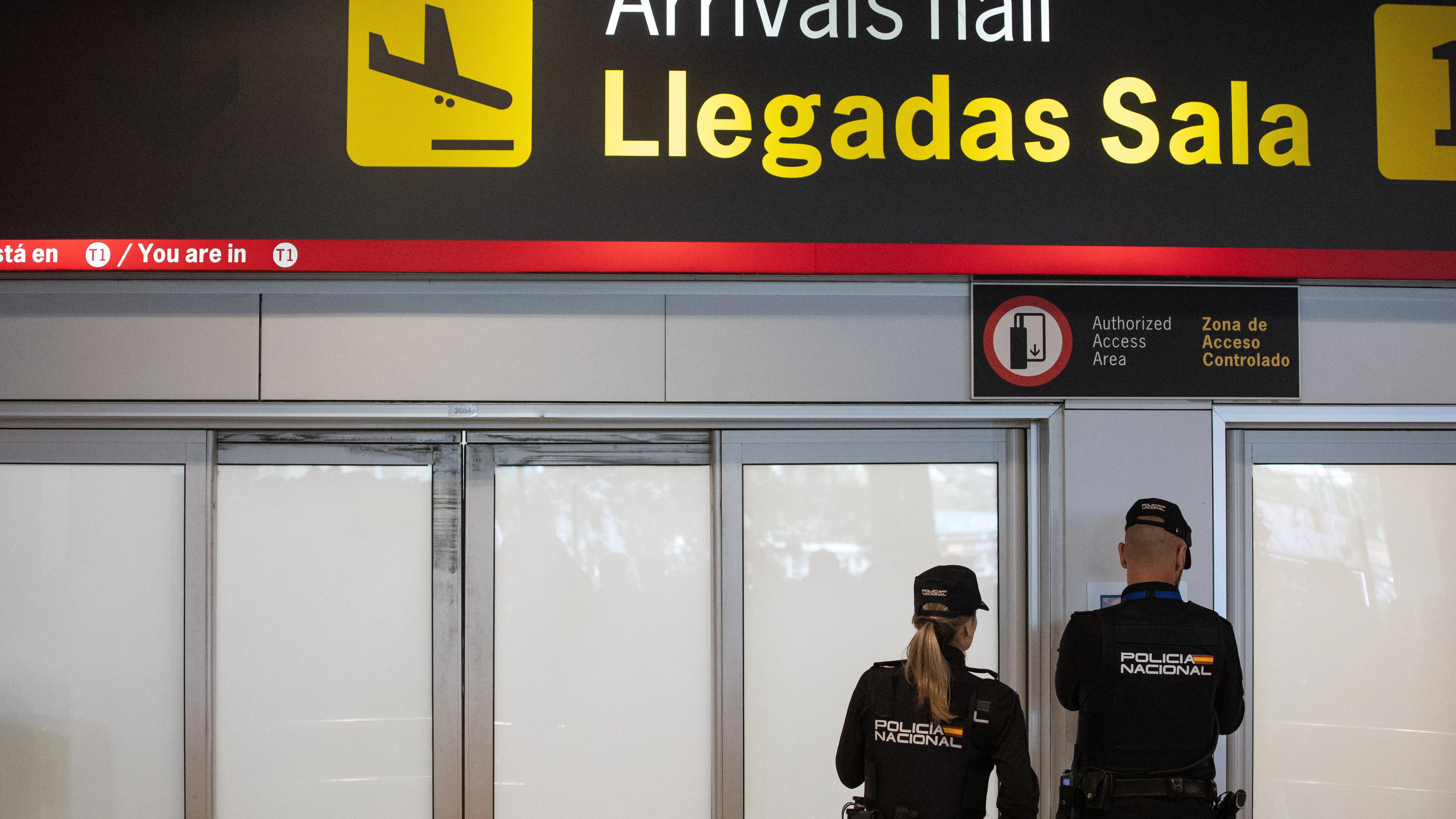 Dos agentes de la Policía Nacional en la puerta de llegadas de la terminal T1 del Aeropuerto Adolfo Suárez Madrid Barajas