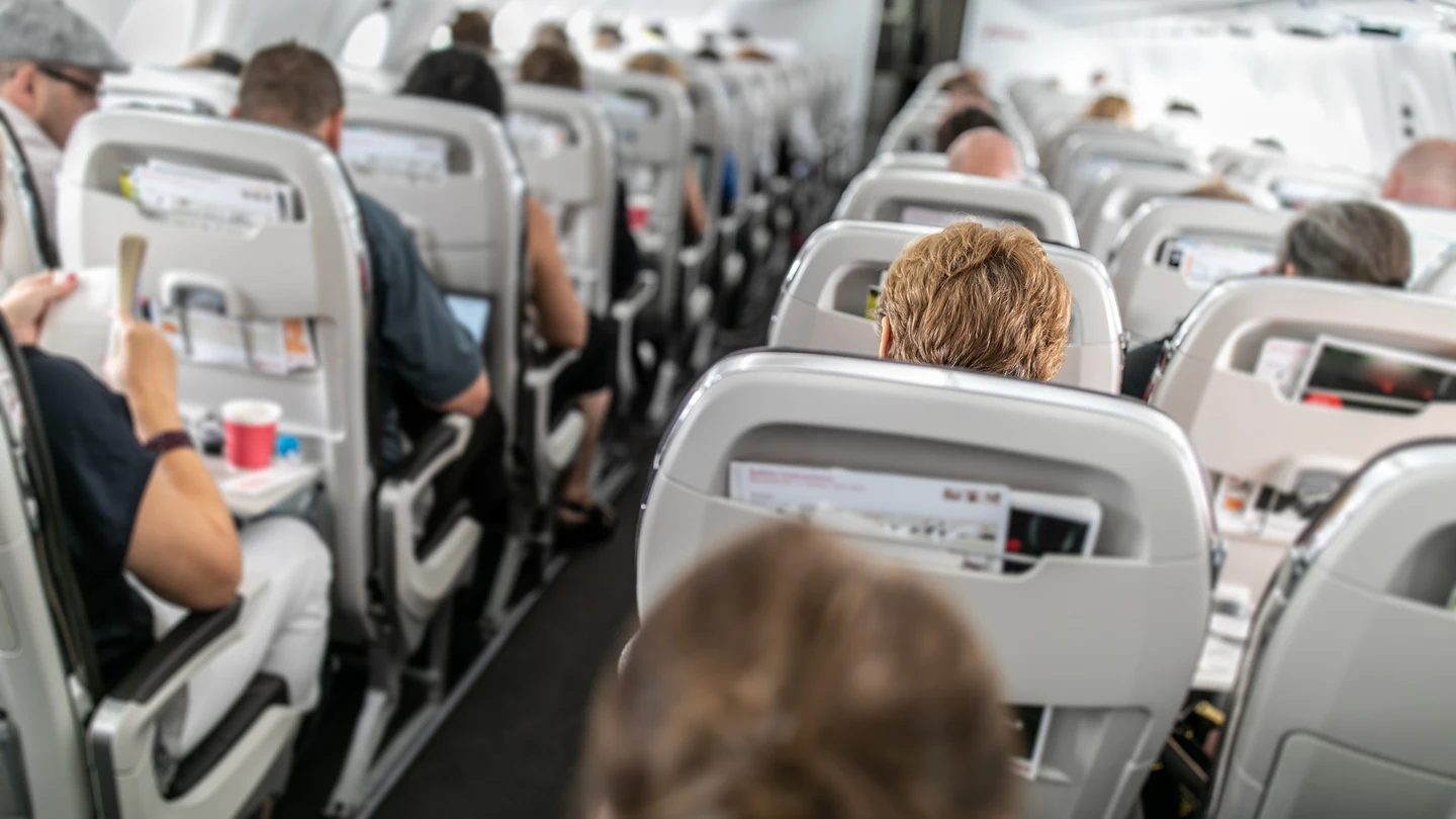 Pasajeros sentados en el avión Pasajeros sentados en el avión