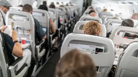 Pasajeros sentados en el avión Pasajeros sentados en el avión