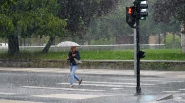 Imagen de archivo. Una mujer se protege de la lluvia con un paraguas.