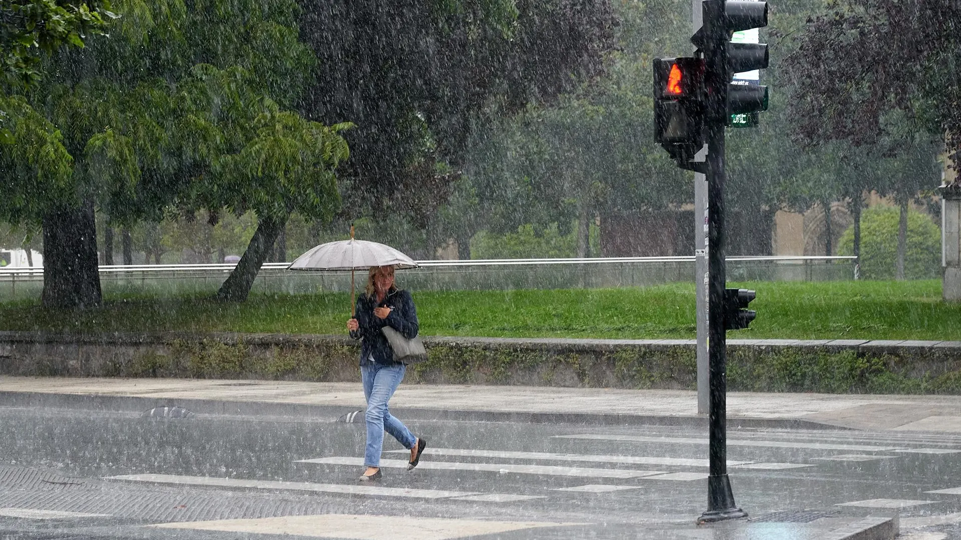 Imagen de archivo. Una mujer se protege de la lluvia con un paraguas.