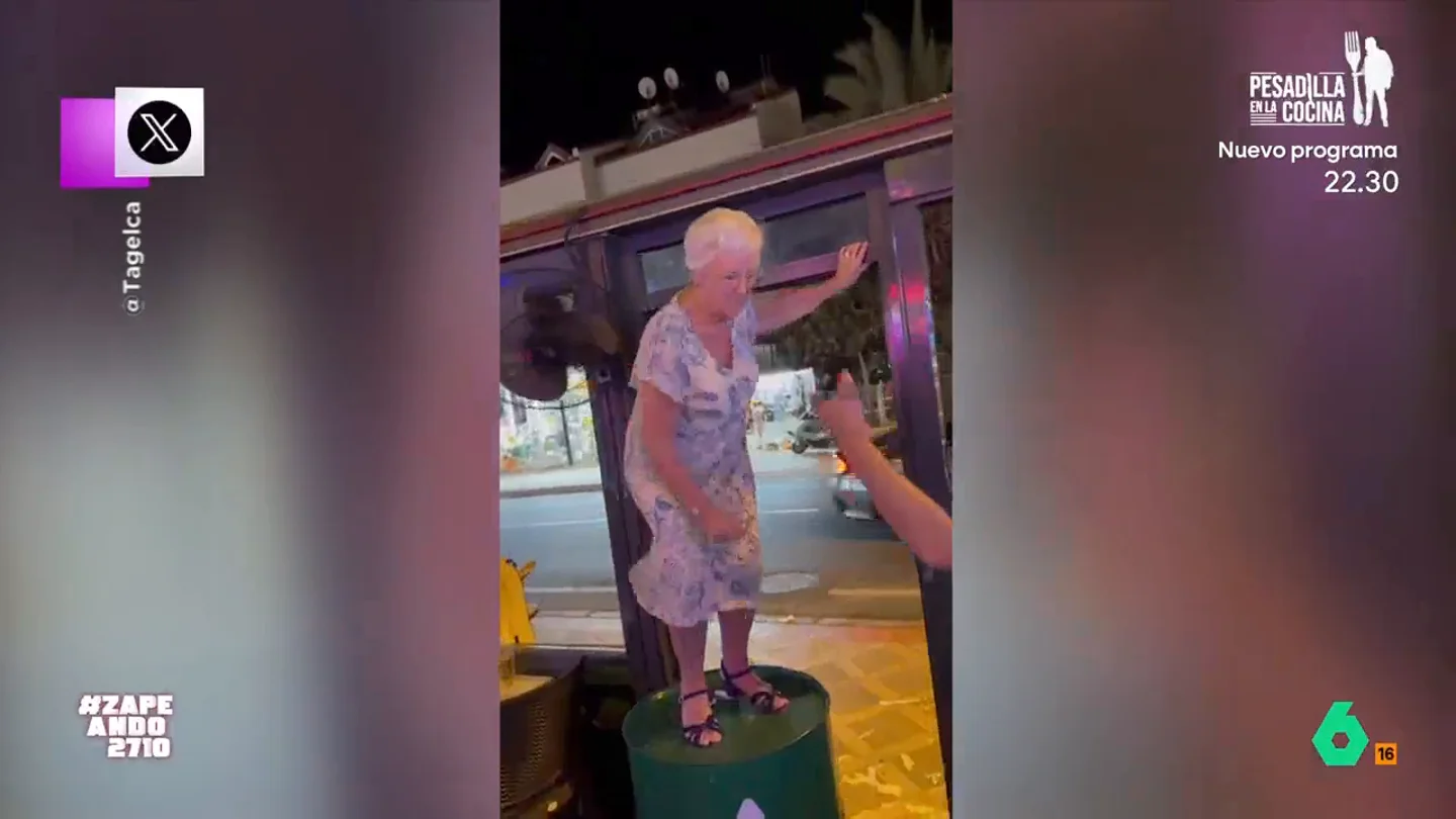 Una señora lo da todo subida en un bidón: "Y luego la gente flipando de como se mueve JLo a su edad" La mujer no se puede resistir a bailar mientras un grupo de jóvenes la animan y bailan a su alrededor. No te pierdas el momentazo en el vídeo principal.