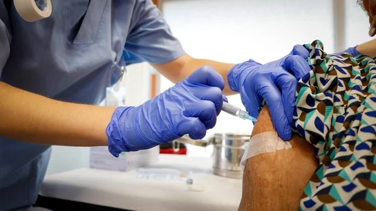 Una señora vacunándose contra la gripe y la COVID Vacuna contra la gripe y la COVID