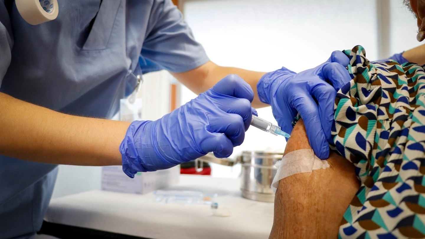 Una señora vacunándose contra la gripe y la COVID Vacuna contra la gripe y la COVID