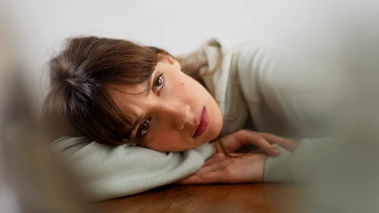 Una triste triste y pensativa tumbada en la cama.  Depresión y tristeza