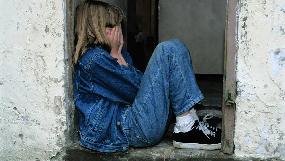 Una joven adolescente se tapa el rostro Una joven adolescente se tapa el rostro