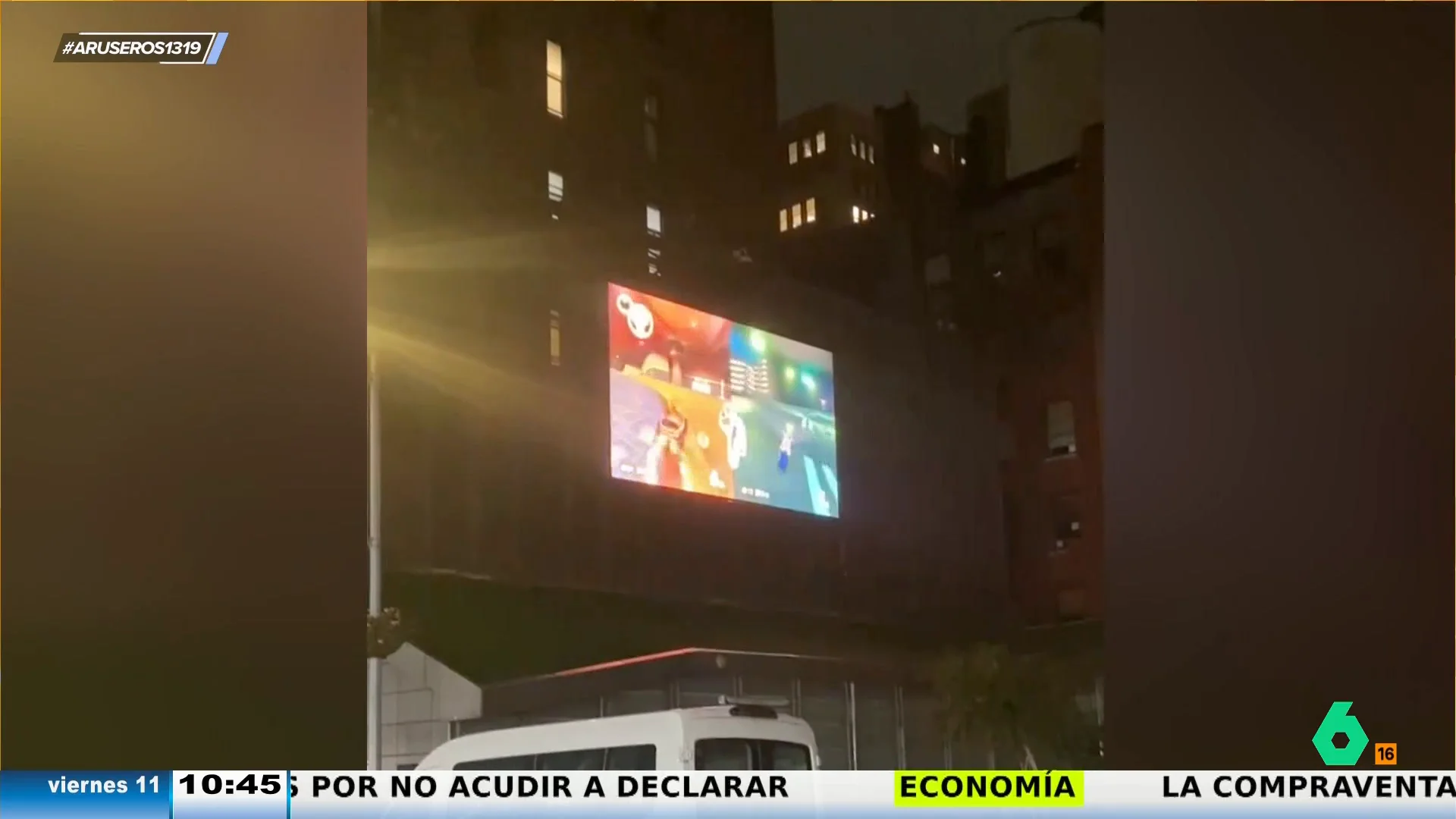 Dos vecinos aprovechan la fachada de una casa para proyectar la partida del Mario Kart