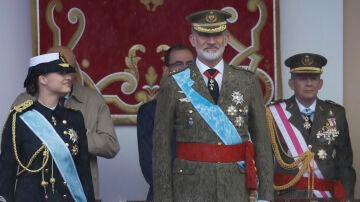 La princesa Leonor lanza una mirada cómplice a su padre, el rey Felipe VI, pasado por agua durante el desfile del 12 de octubre de 2024.