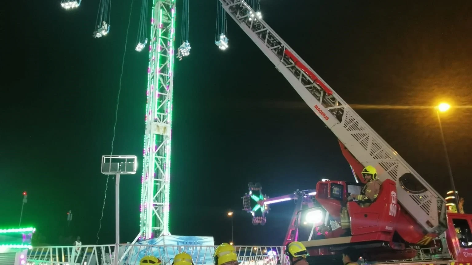 Bomberos de Zaragoza con la autoescala frente a la atracción del columpio gigante este domingo de madrugada en el recinto ferial de Valdespartera, donde fueron restacadas 14 personas.