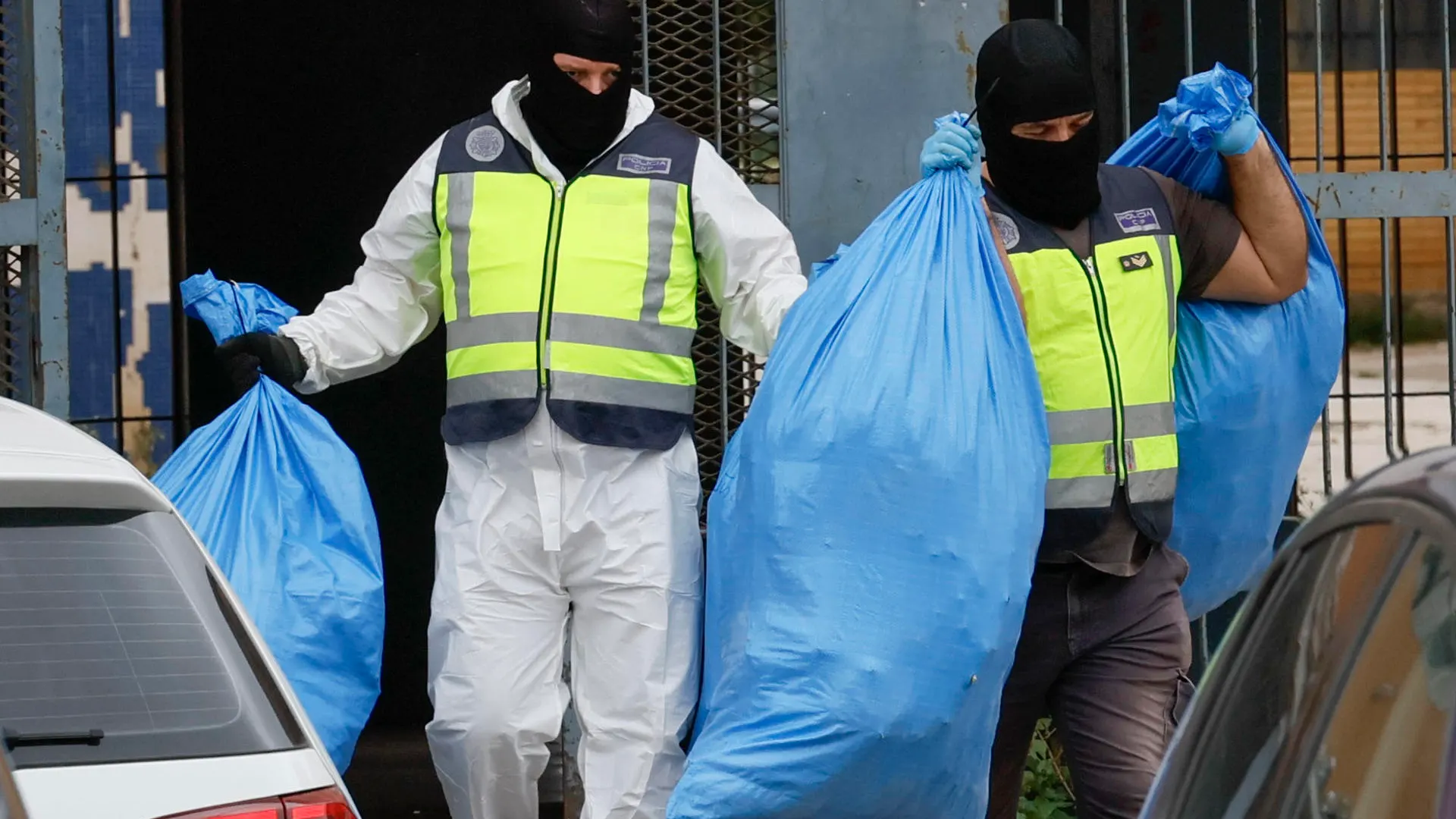 Agentes de la Policía salen de un registro con bolsas con material requisado