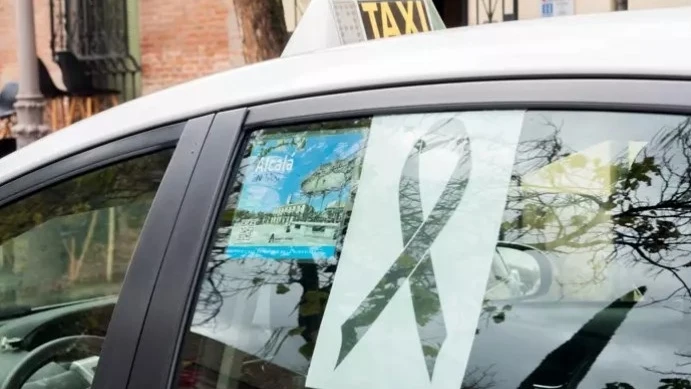 Un taxi con el lazo negro durante el minuto de silencio en Alcalá