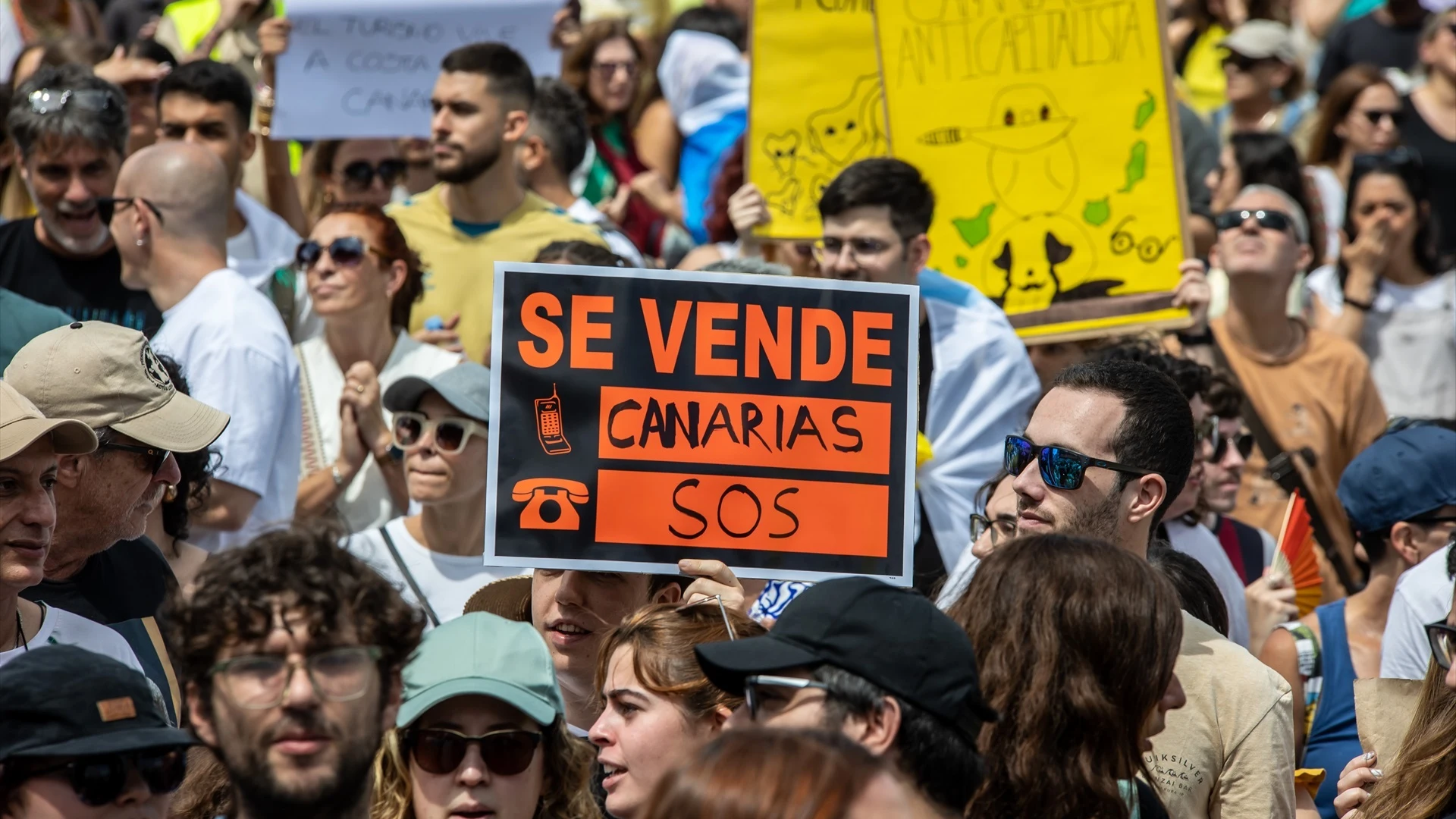 Decenas de personas protestan con carteles durante una manifestación contra el modelo turístico