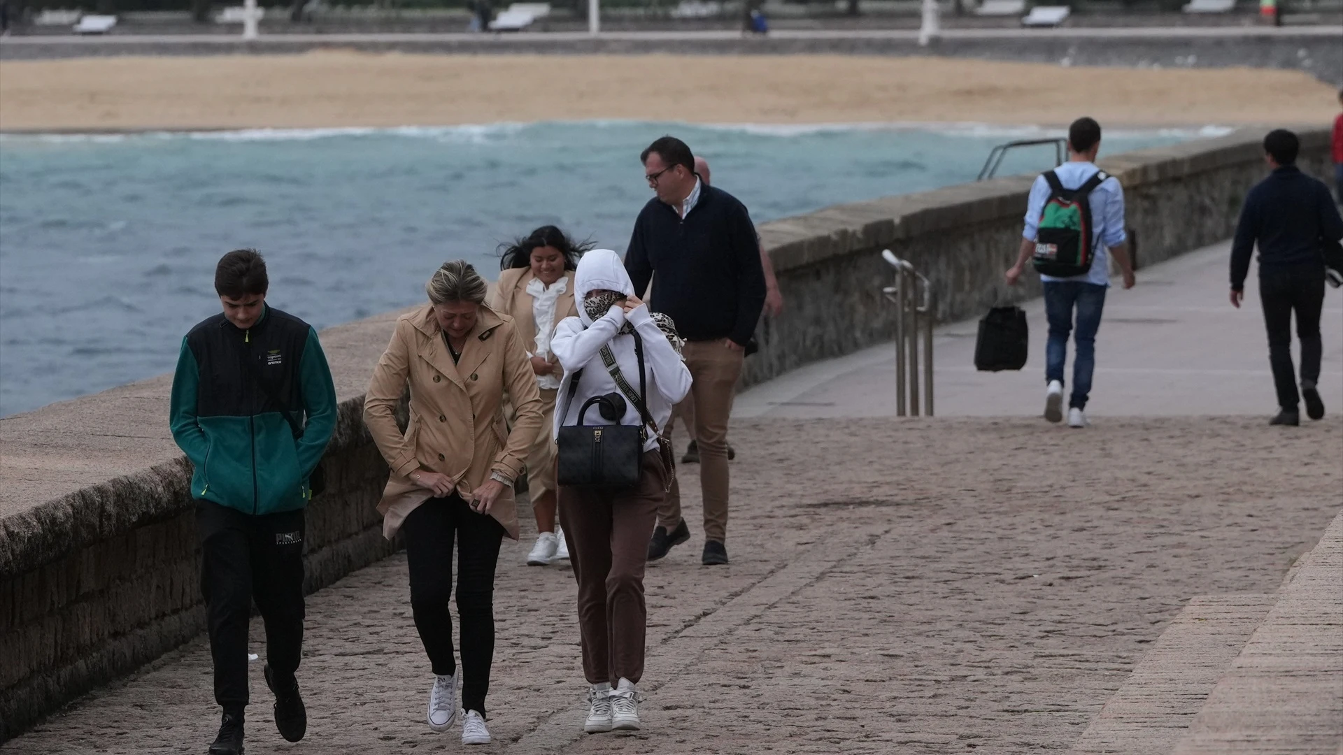 Imagen de archivo de varias personas caminando bajo la lluvia.