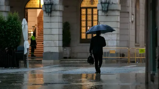 Imagen de archivo de una persona protegiéndose de la lluvia. Imagen de archivo de una persona protegiéndose de la lluvia.