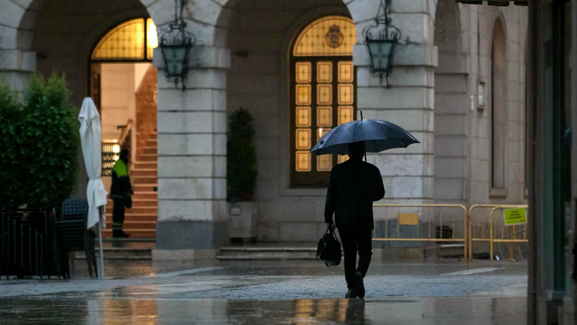 Imagen de archivo de una persona protegiéndose de la lluvia.