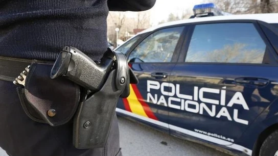Imagen de archivo de un agente y un coche de la Policía Nacional. Imagen de archivo de un agente y un coche de la Policía Nacional.