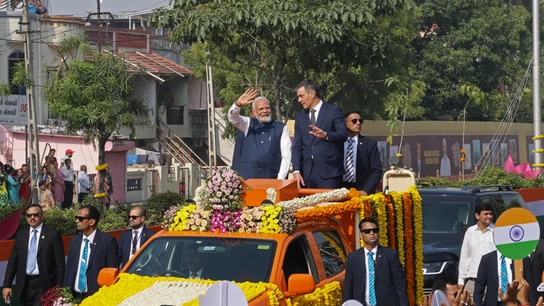 Narendra Modi y Pedro Sánchez saludan a la gente desde un vehículo en Vadodara. Narendra Modi y Pedro Sánchez saludan a la gente desde un vehículo en Vadodara.