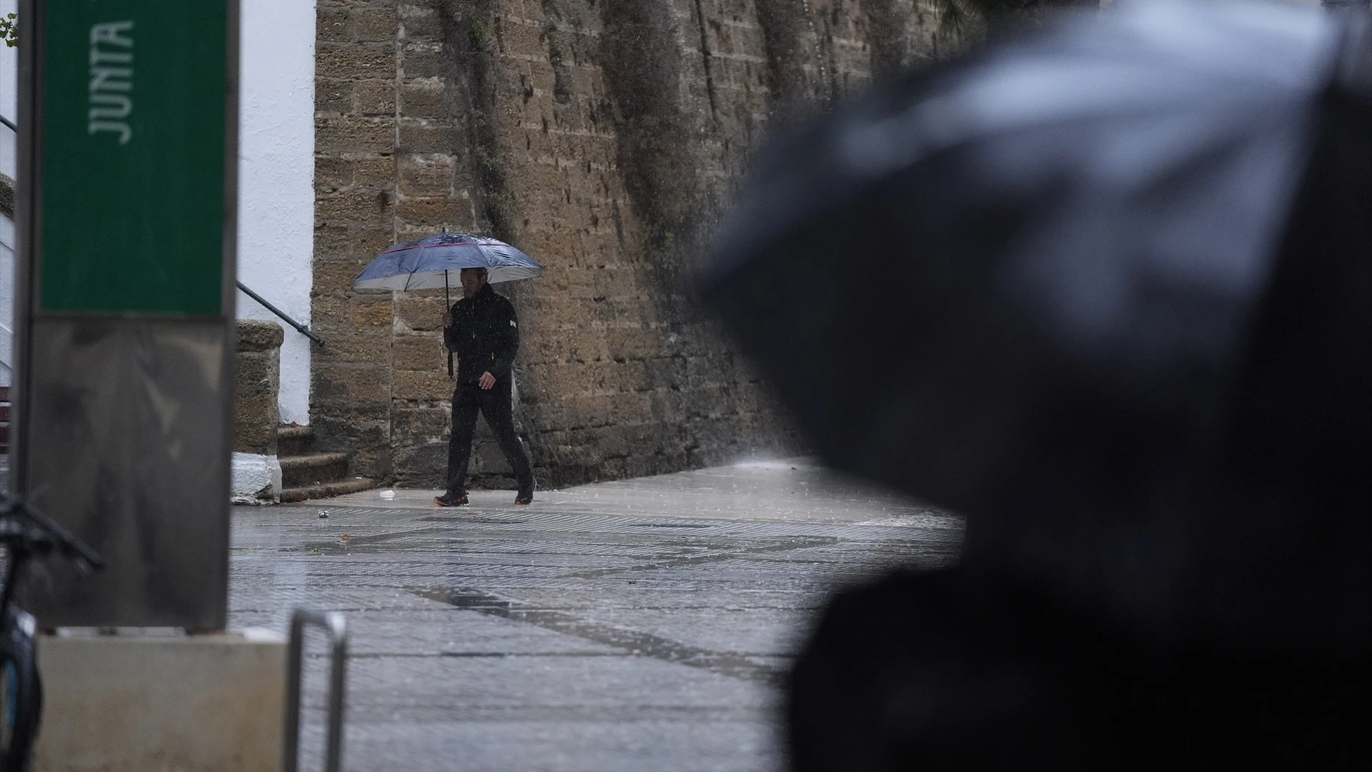 Personas bajo sus paraguas durante la intensa lluvia.