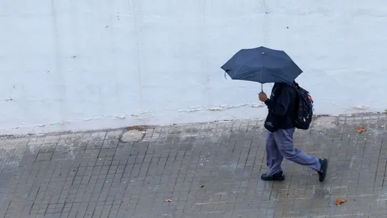 Un joven se protege de la lluvia con un paraguas en Valencia, en una imagen de archivo Un joven se protege de la lluvia con un paraguas en Valencia, en una imagen de archivo