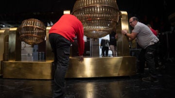 Personal de mantenimiento desplaza uno de los bombos del Sorteo Extraordinario de Navidad, en el Teatro Real, a 15 de diciembre de 2023, en Madrid (España). 