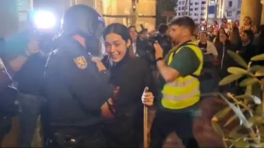 Un antidisturbios consuela a una asistente a la manifestación de Valencia Un antidisturbios consuela a una asistente a la manifestación de Valencia