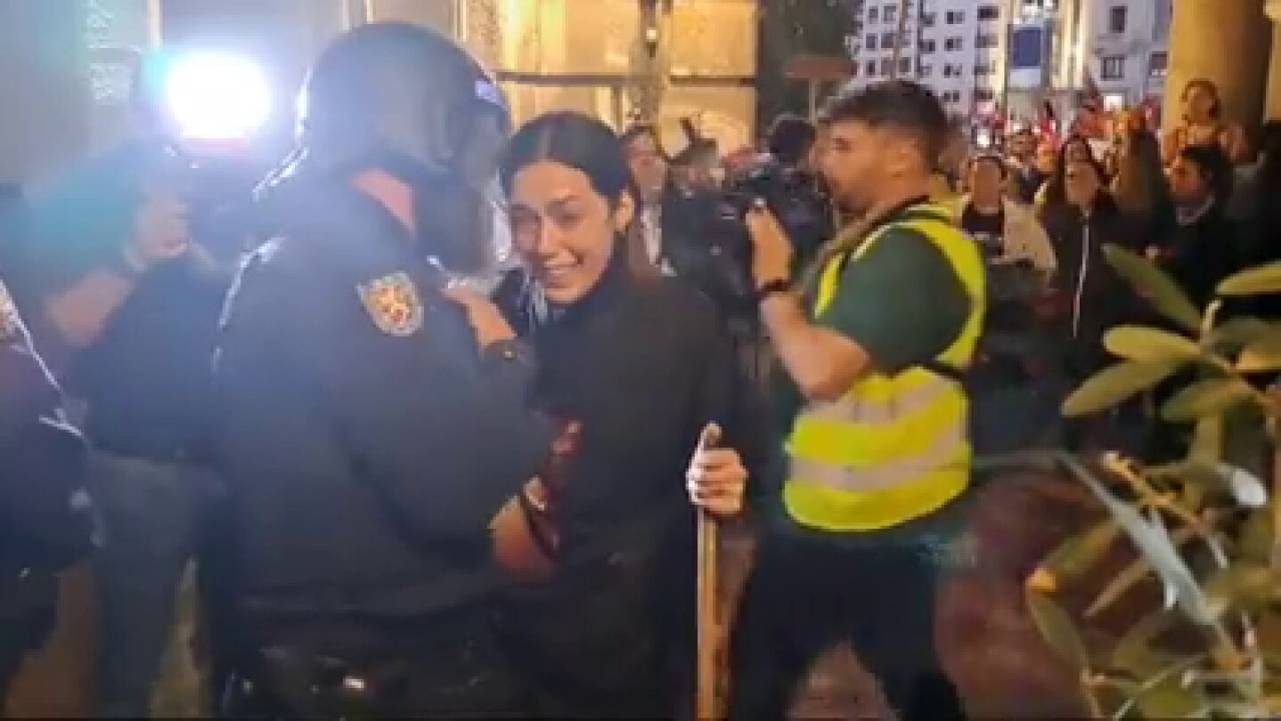 Un antidisturbios consuela a una asistente a la manifestación de Valencia
