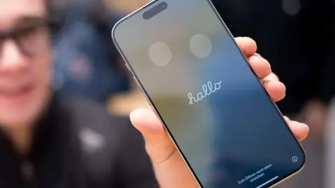 Mujer sostiene un iPhone en la mano Mujer sostiene un iPhone en la mano