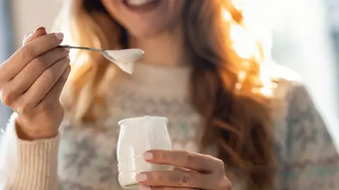 Mujer tomando un yogur Mujer tomando un yogur