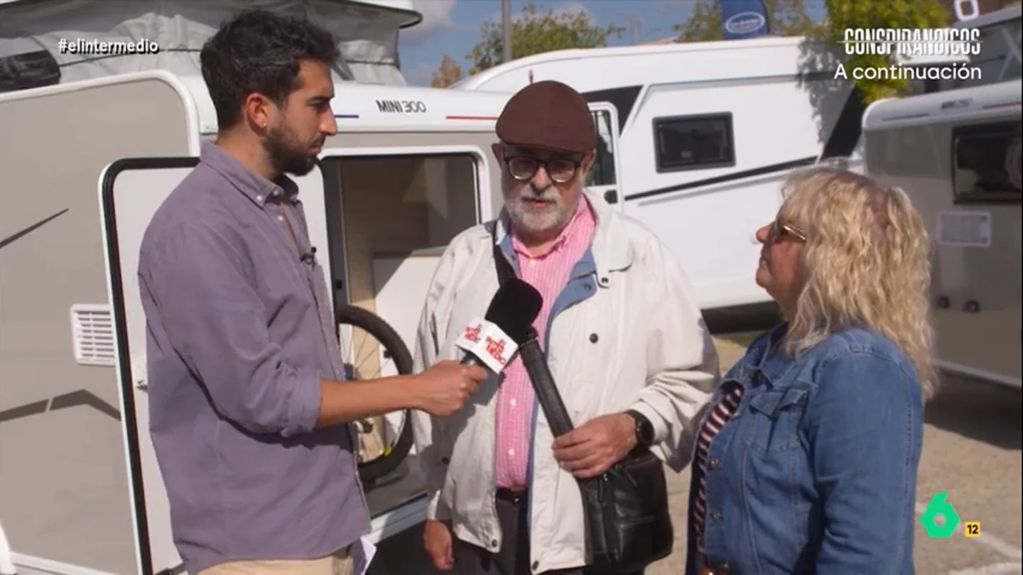 Isma Juárez, a un hombre que no sabe cuántos años lleva casado: "Me ha dicho todas las piezas de la caravana..." El reportero charla con un matrimonio en una feria dedicada a estos vehículos que le explican que han ido a curiosear debido a que se están planteando renovar su caravana a un modelo más moderno.