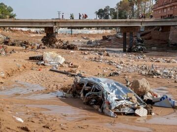 Restos de vehículos arrastrados por la corriente en el barranco del Poyo en Paiporta, Valencia