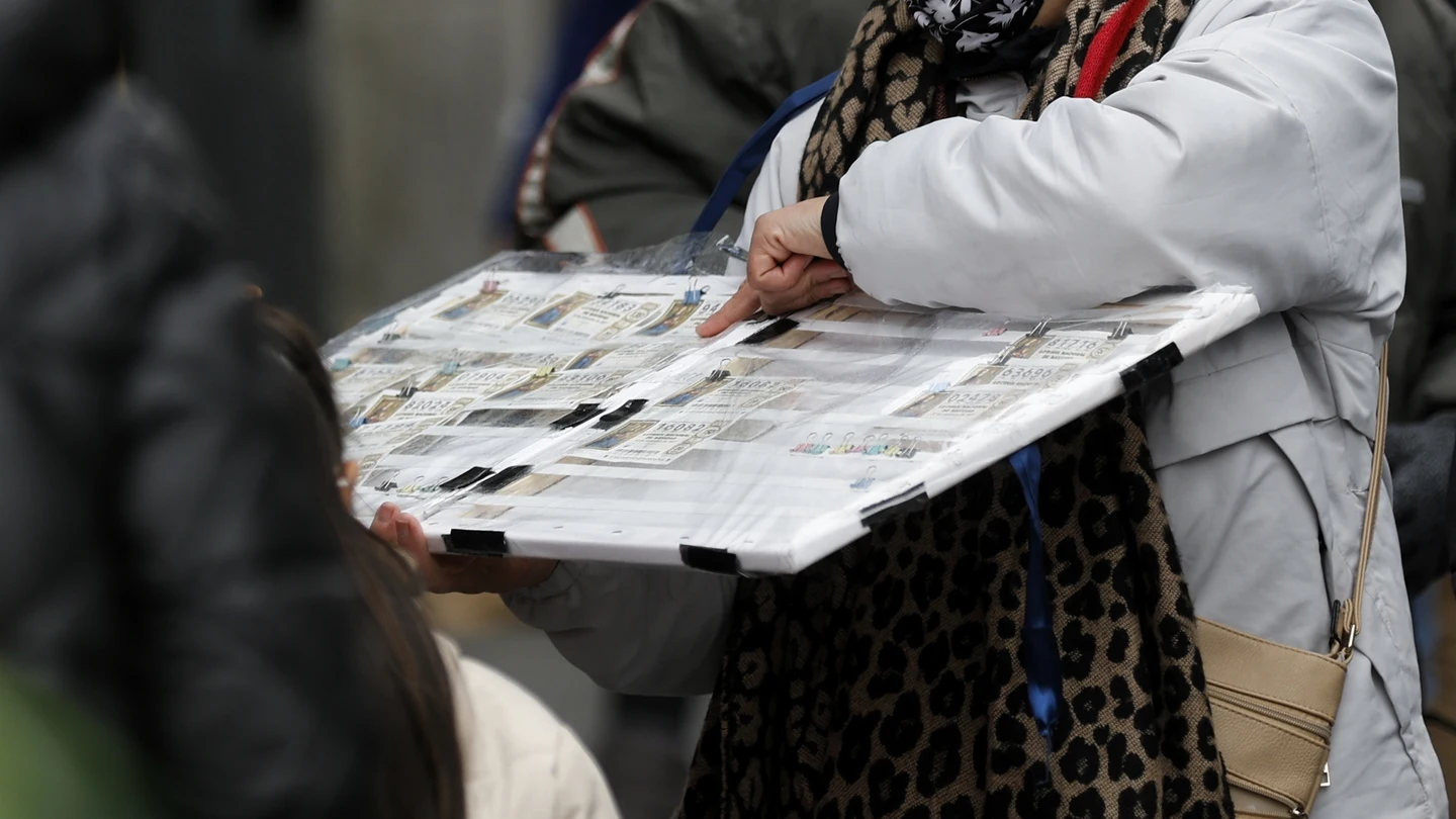 Una personas compra un décimo de lotería de Navidad a una vendedora ambulante cuando quedan menos de tres semanas para el Sorteo Extraordinario de la Lotería de Navidad. Una personas compra un décimo de lotería de Navidad a una vendedora ambulante cuando quedan menos de tres semanas para el Sorteo Extraordinario de la Lotería de Navidad.