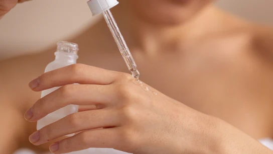 Mujer aplicándose un sérum. Mujer aplicándose un sérum.
