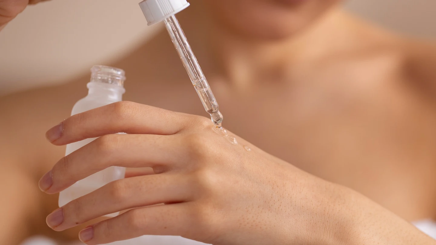 Mujer aplicándose un sérum. Mujer aplicándose un sérum.