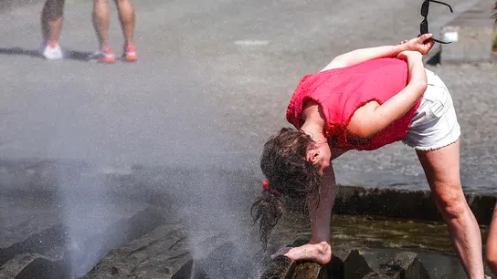 Una mujer se refresca con agua durante una ola de calor Una mujer se refresca con agua durante una ola de calor