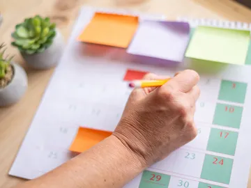 Joven organizándose el calendario laboral Joven organizándose el calendario laboral