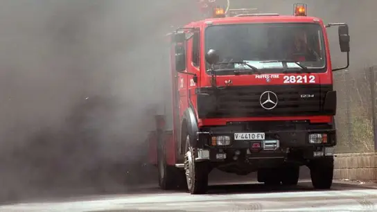 Un camión de bomberos sale de la intensa humareda. Un camión de bomberos sale de la intensa humareda.