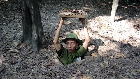 Soldado mostrando una entrada a los túneles Cu Chi, en Vietnam Soldado mostrando una entrada a los túneles Cu Chi, en Vietnam