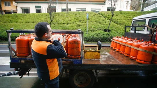 Un repartidor de bombonas de butano descarga una bombona del camión. Un repartidor de bombonas de butano descarga una bombona del camión en Lugo (Galicia).