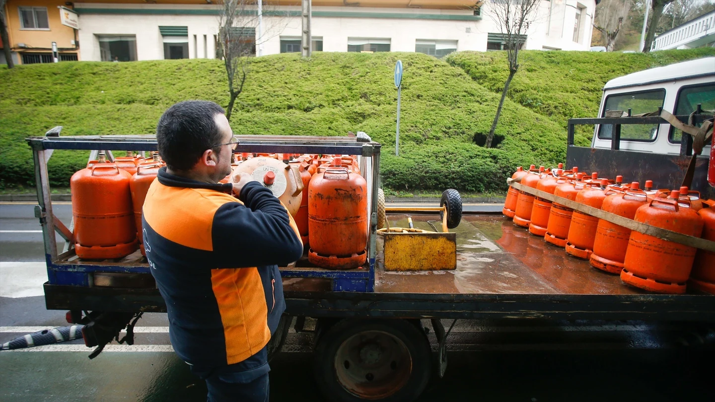 Un repartidor de bombonas de butano descarga una bombona del camión. Un repartidor de bombonas de butano descarga una bombona del camión en Lugo (Galicia).