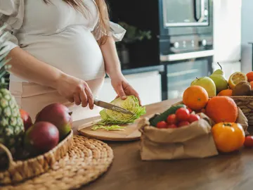 Mujer embarazada preparando una ensalada Mujer embarazada preparando una ensalada